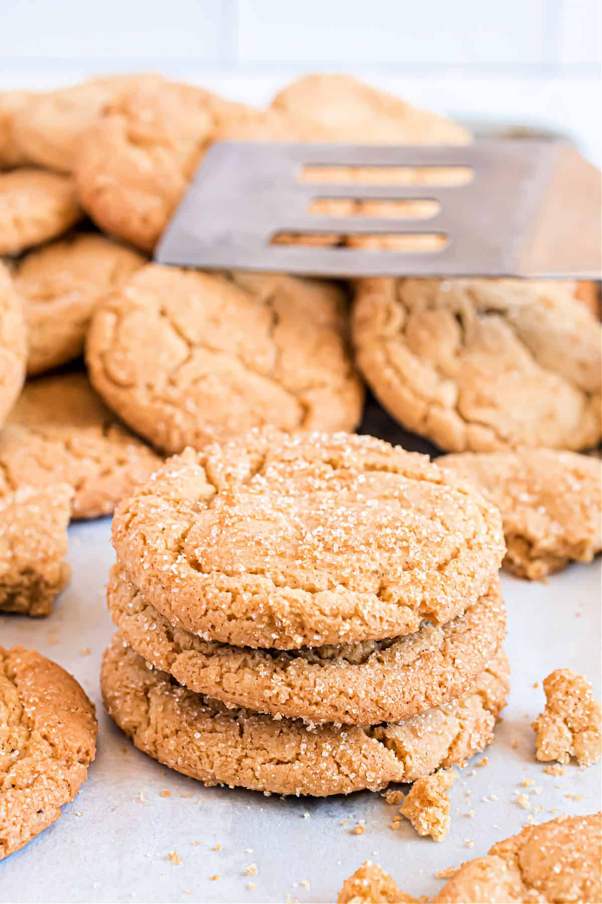 Stack of three butterscotch cookies on parchment paper.