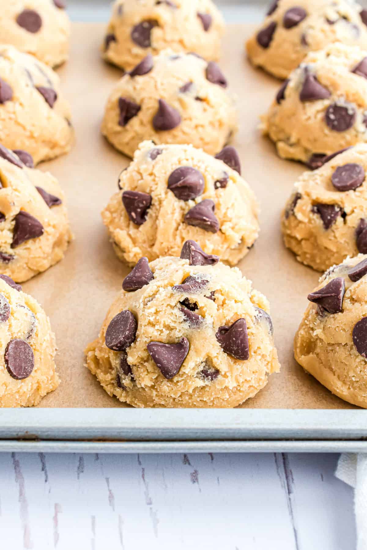 Chocolate chip cookie dough on parchment paper lined cookie sheet for freezing.