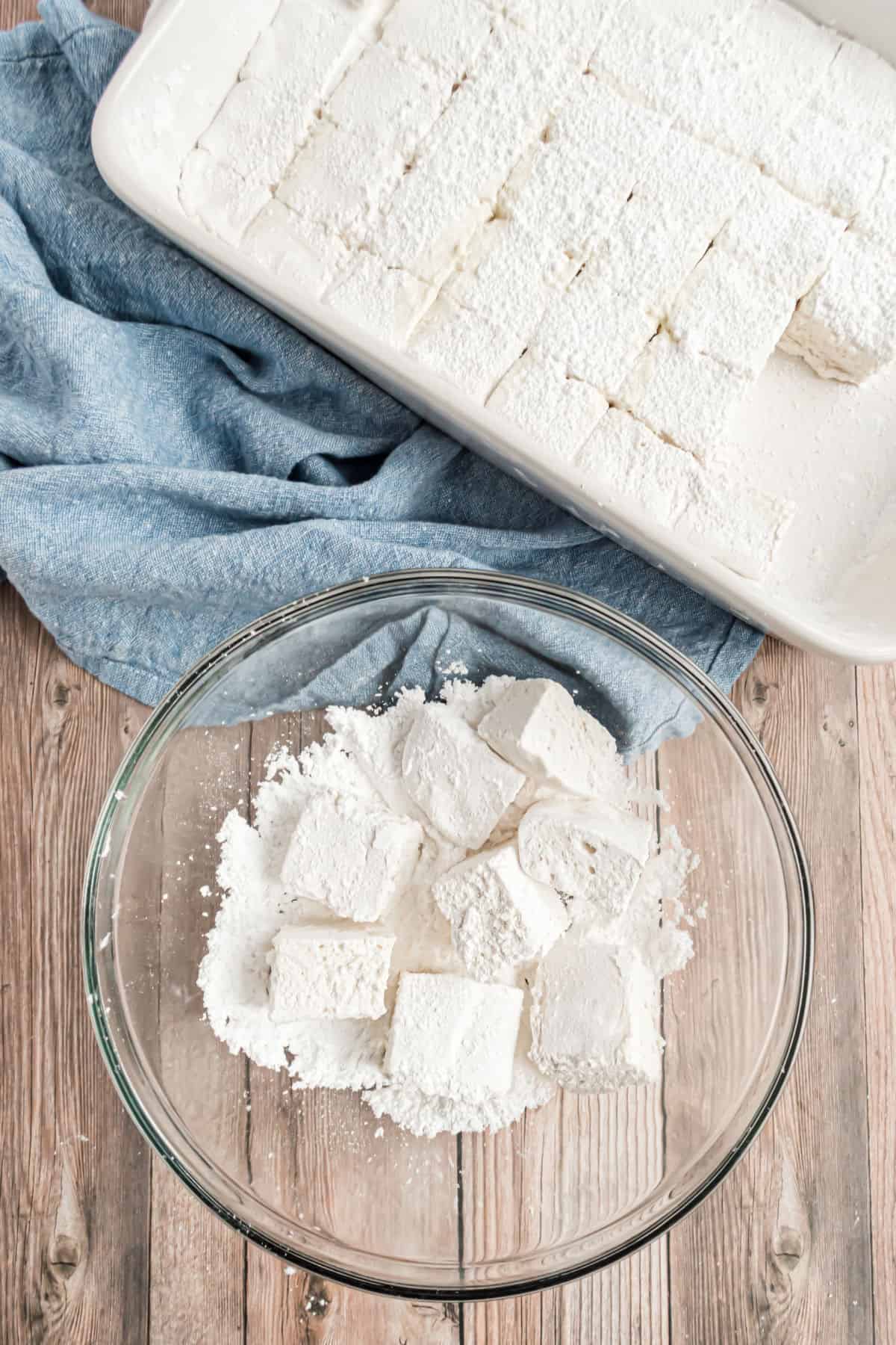 Cut marshmallows in bowl of powdered sugar.
