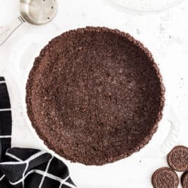 Oreo pie crust in white pie plate.