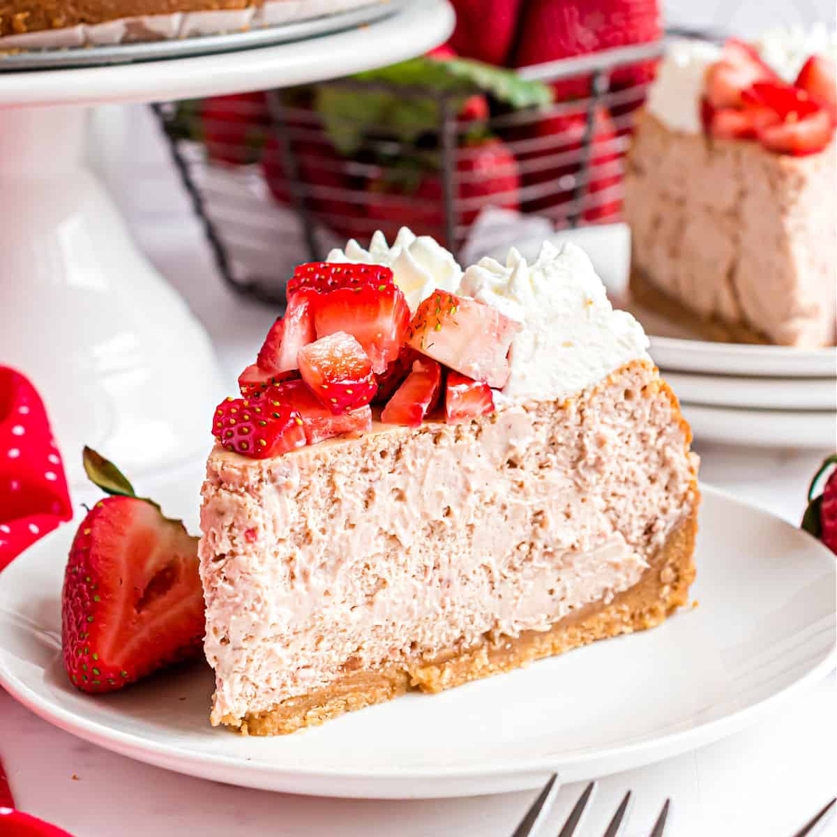 Slice of strawberry cheesecake topped with fresh berries and whipped cream.