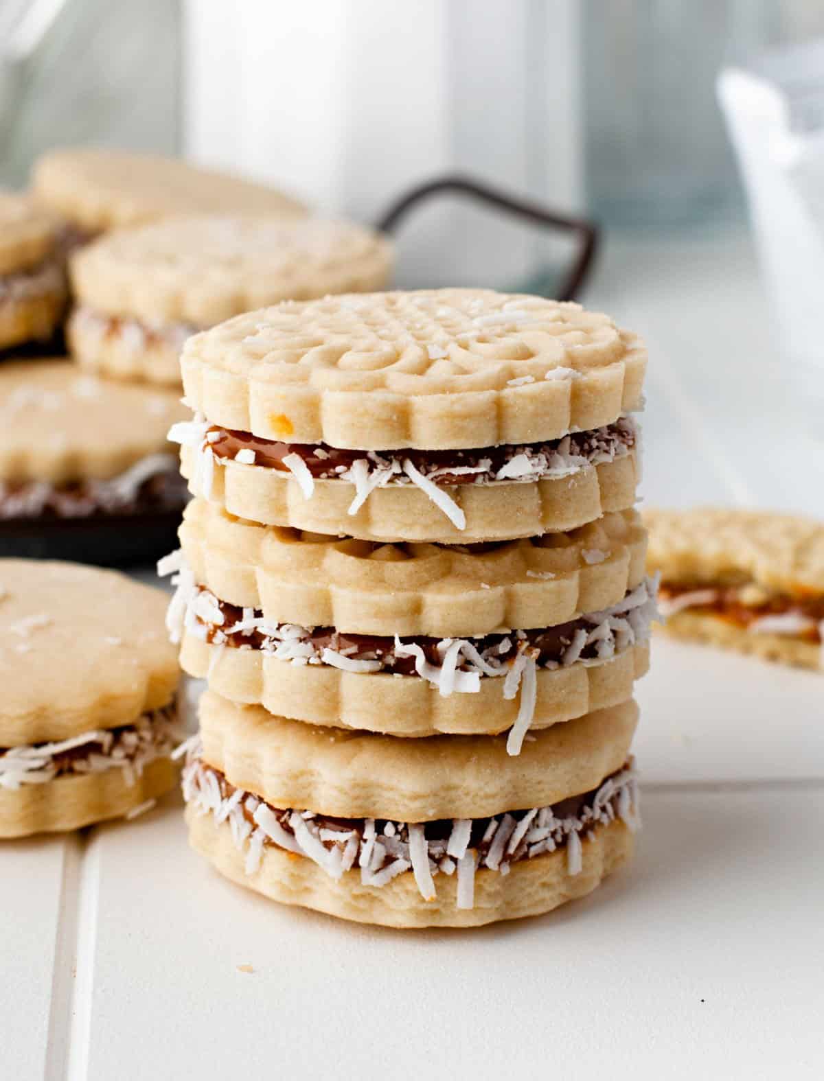 Stack of three dulce de leche cookies on white counter.