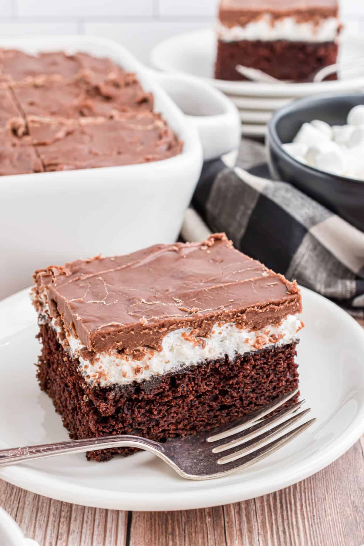 Slice of mississippi mud cake on white plate with fork.