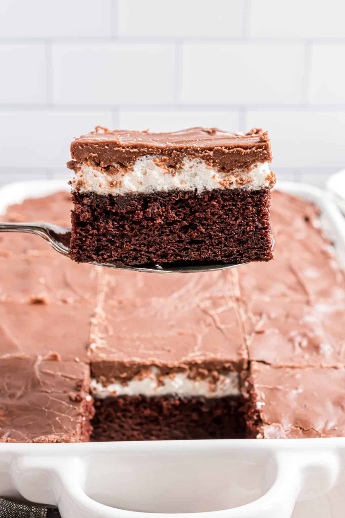 Slice of chocolate cake being lifted out of baking dish.