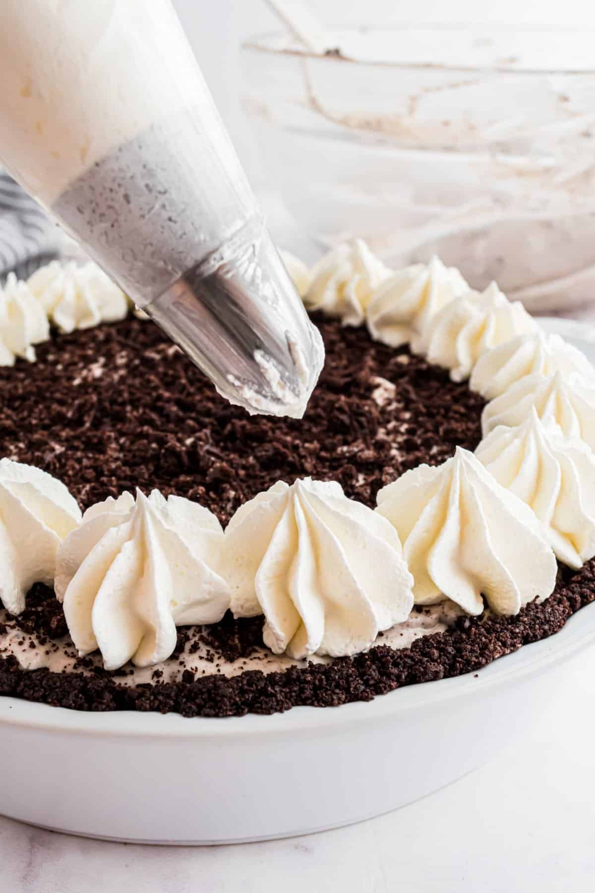 Stabilized whipped cream piped onto an oreo cheesecake.