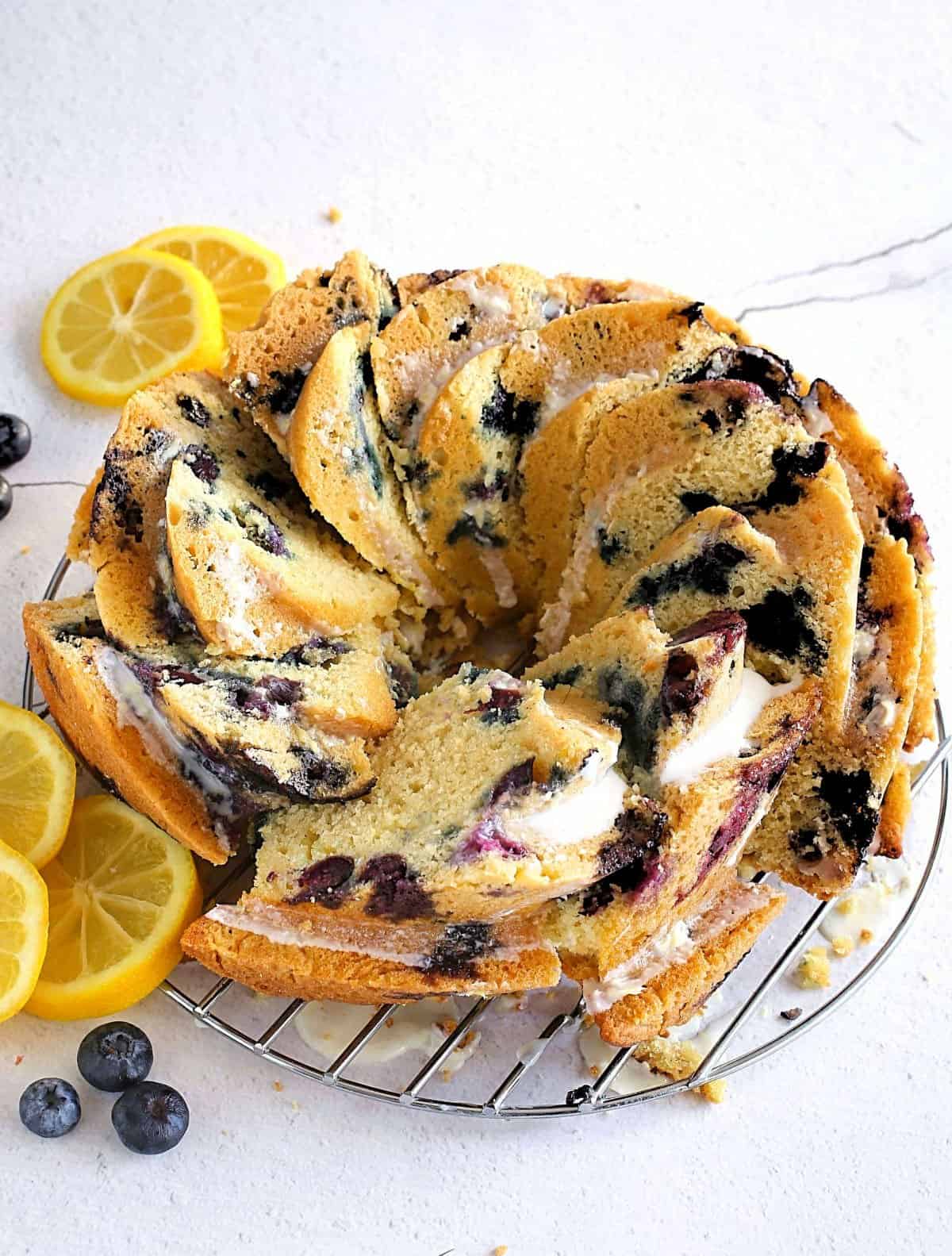 Bundt cake with blueberries sliced on a wire rack.