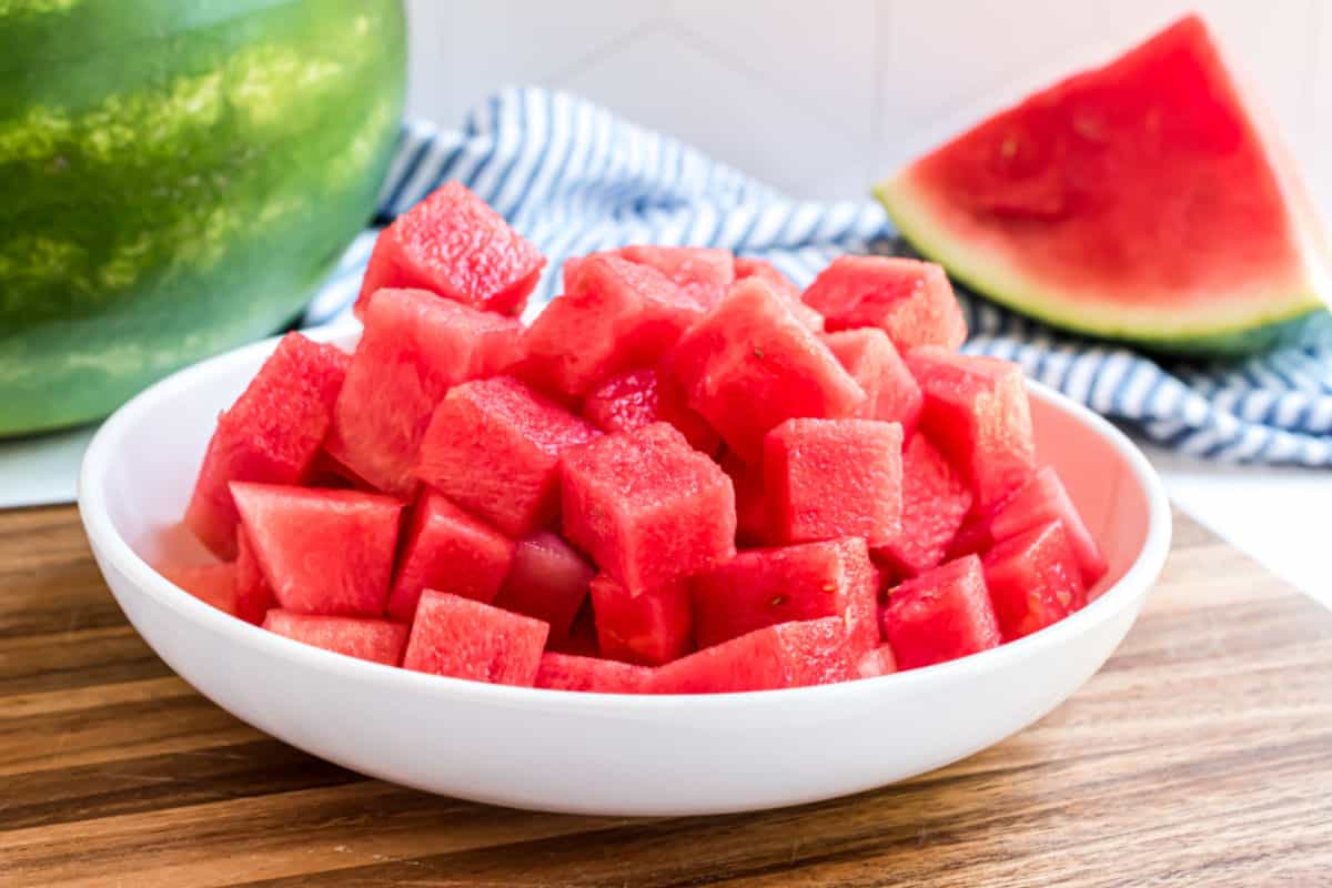 Watermelon cut into cubes and served in a white bowl.