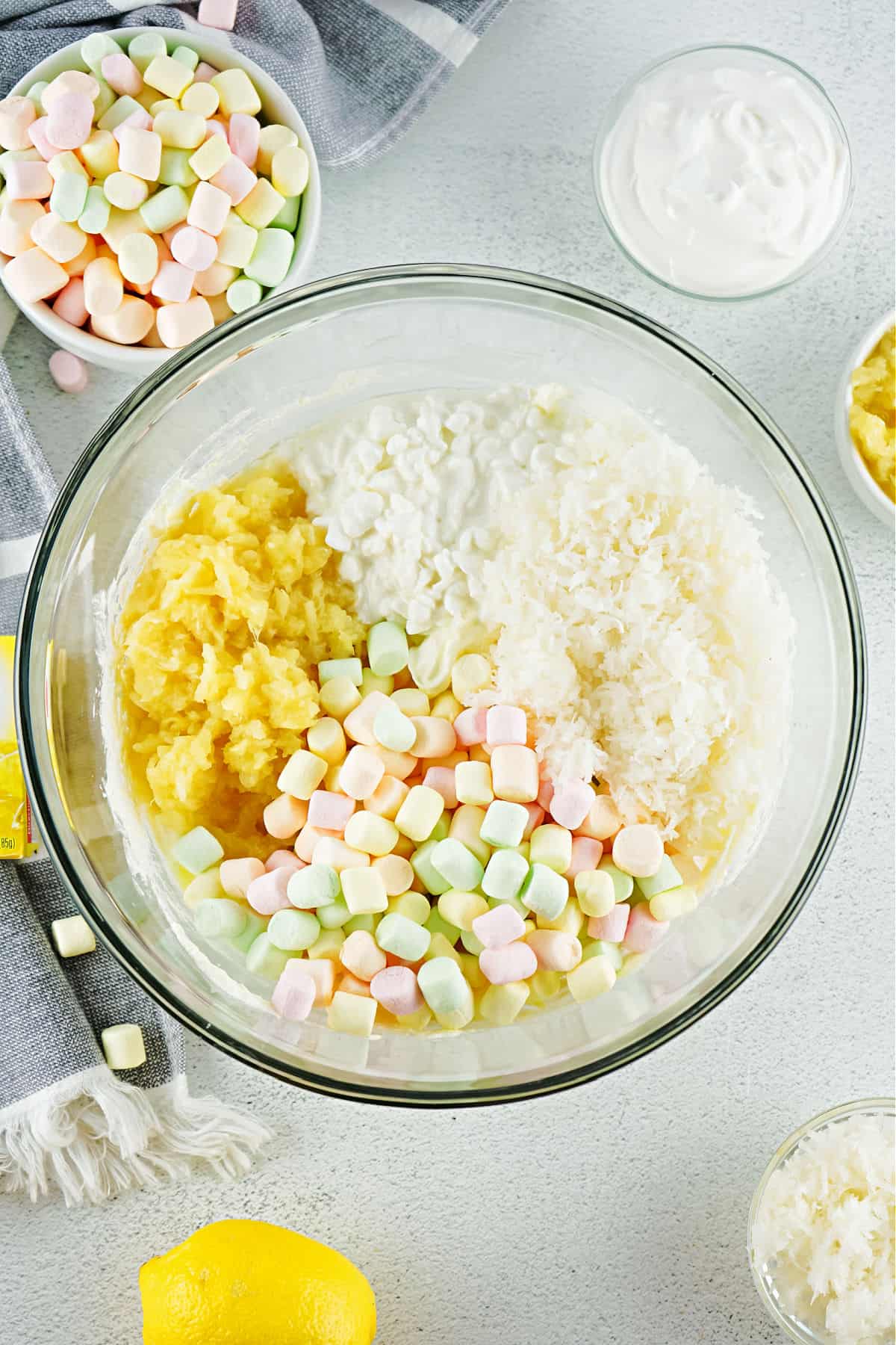 Lemon fluff ingredients in a clear glass bowl before mixing.