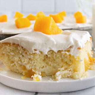 Peach Sheet Cake is simple to make, super moist and brimming with peaches and cream flavor! We combine a yellow cake mix with canned peaches and a dreamy whipped topping in this easy sheet cake recipe.