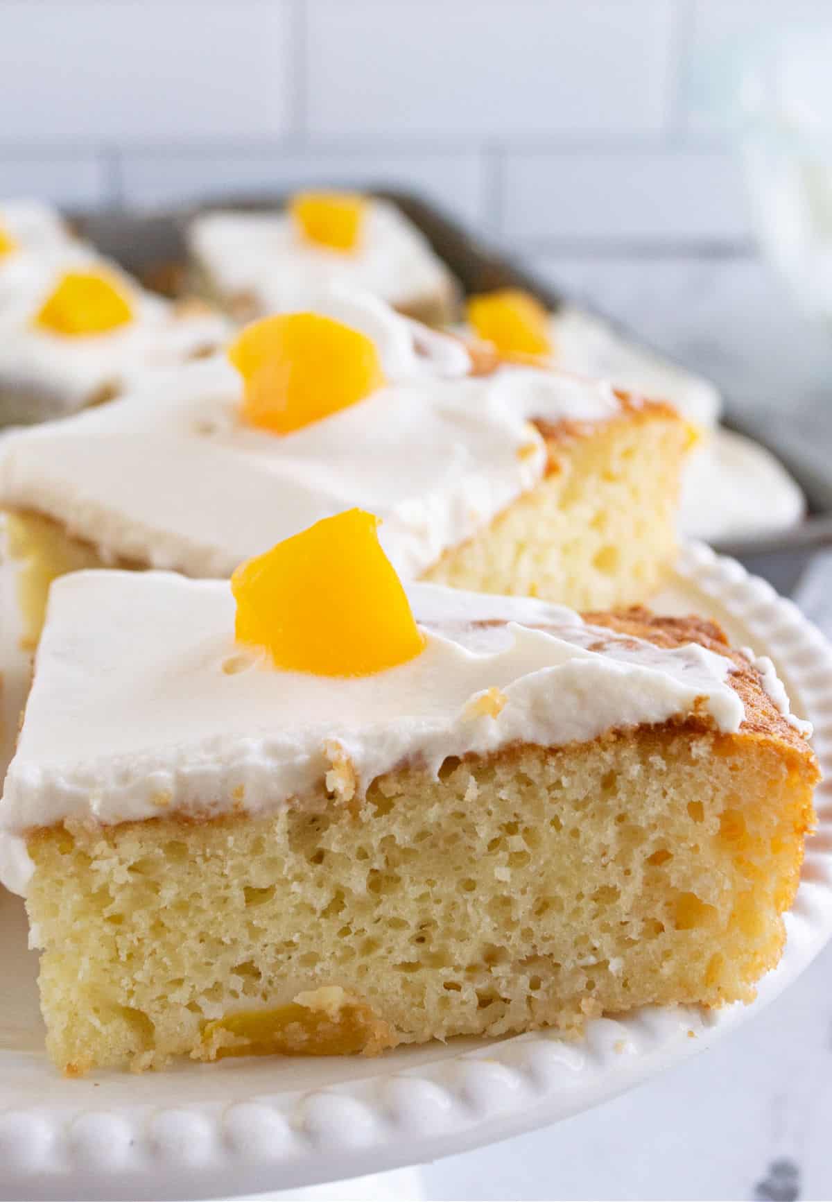 Slice of peach cake on a white plate.