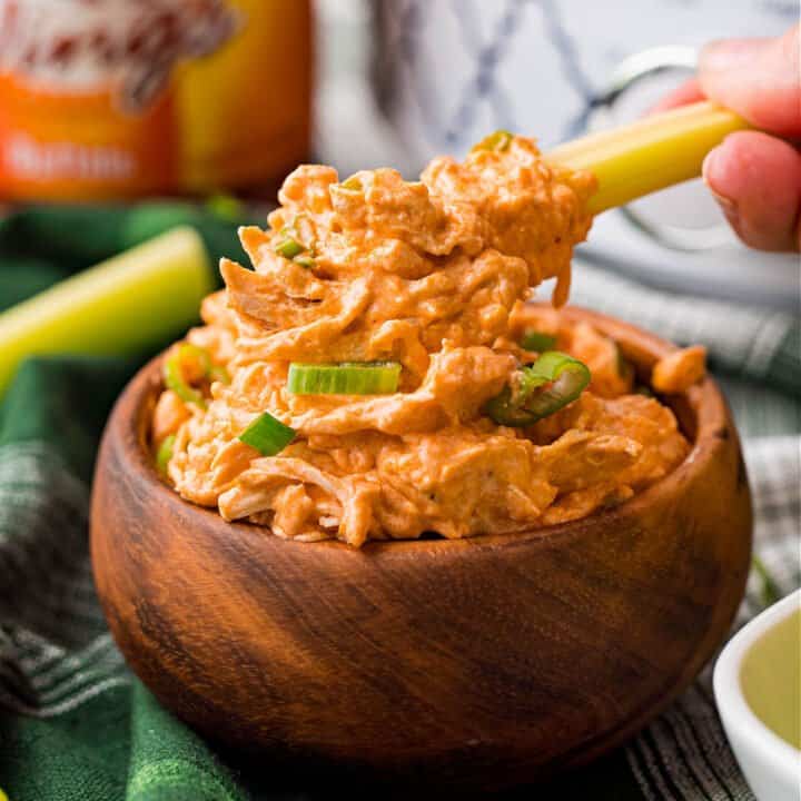 This Slow Cooker Buffalo Chicken Dip recipe makes game day more delicious! Zesty Buffalo wing sauce is loaded with shredded chicken, topped with cheese and heated in the slow cooker. Grab a bag of tortilla chips and dig in!