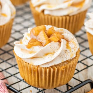 Caramel Apple Cupcakes have a fun apple pie filling in the middle, are topped with an easy, homemade buttercream frosting and served with some extra apple filling on top. These moist cupcakes are full of warm spices and such a fun and pretty fall dessert!