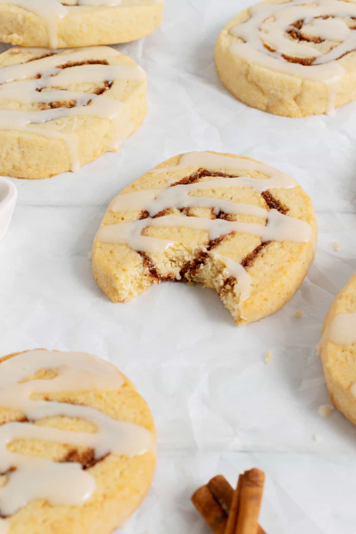 Cinnamon roll cookie with a bite taken out.