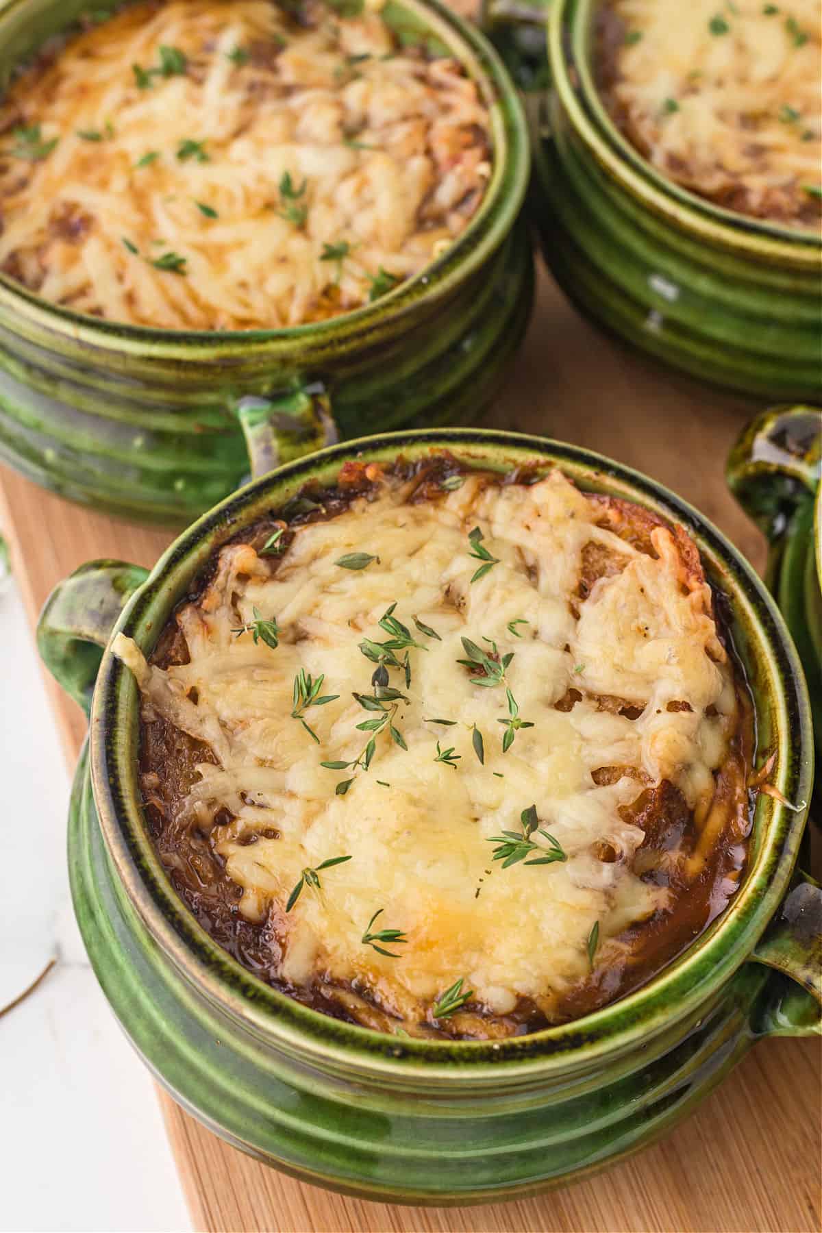 French onion soup served in green soup bowls.