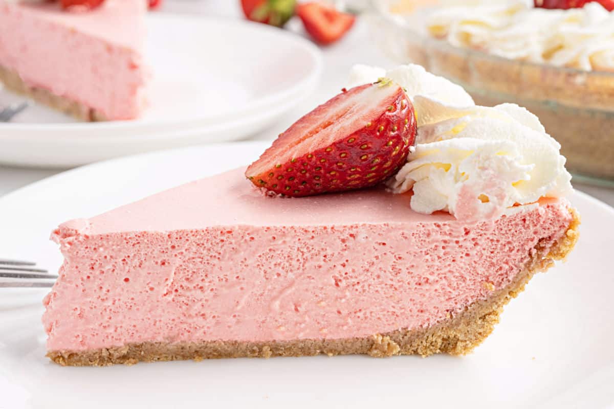 Slice of strawberry jello pie on a white plate.