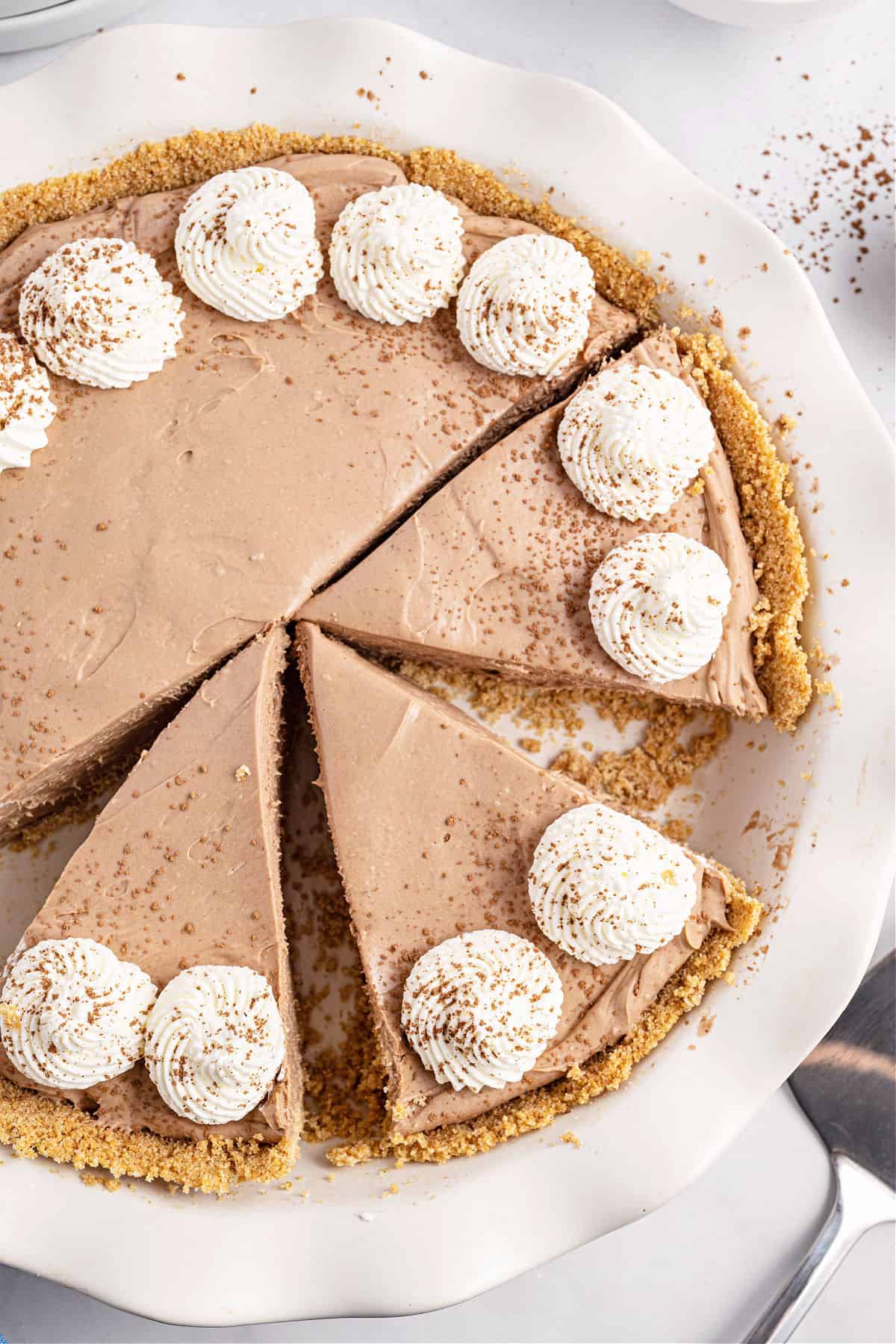 Nutella cheesecake in a white pie plate with slices cut.