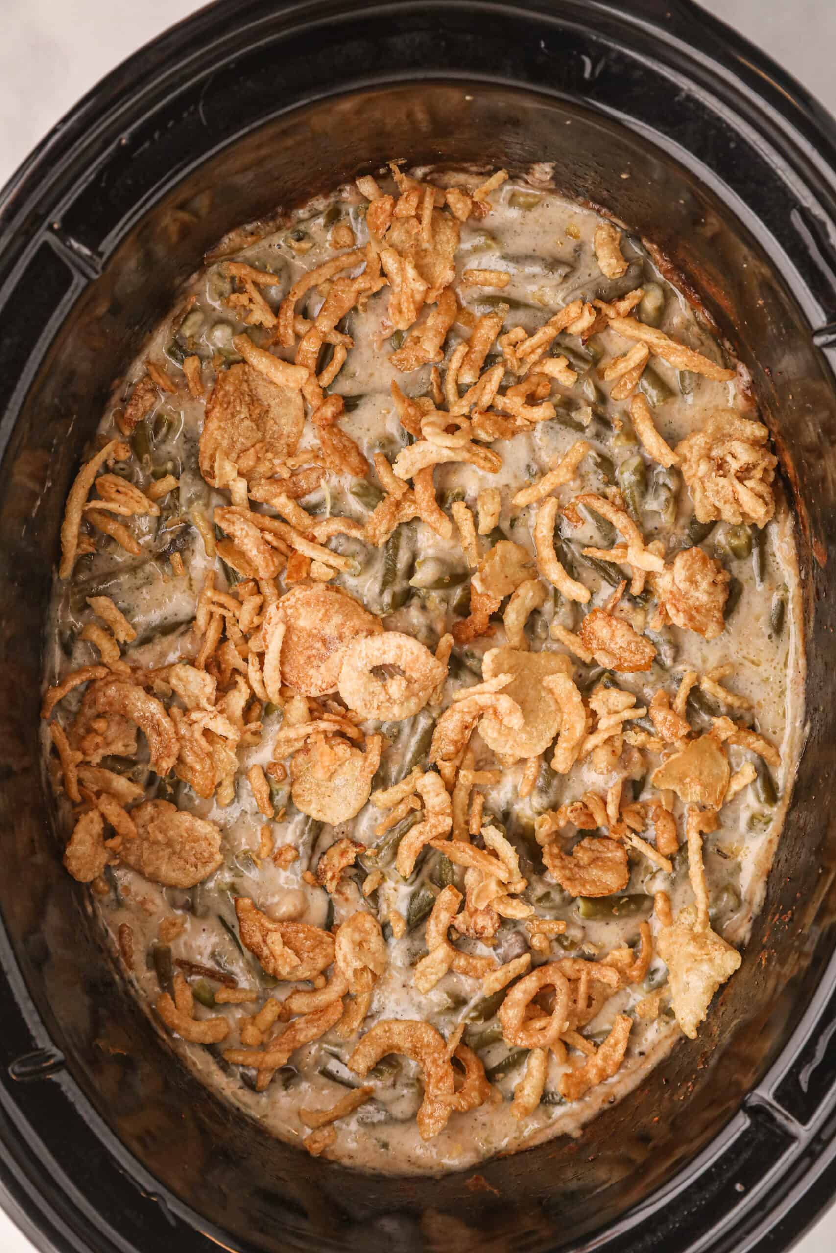 Green bean casserole cooked in crockpot and topped with french's crispy fried onions.