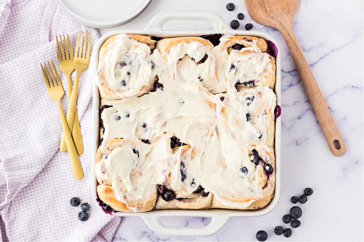 Blueberry rolls baked in a white baking dish.