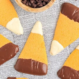 These festive Candy Corn Sugar Cookies have a soft, buttery sugar cookie base that's shaped in a triangle and topped with melted chocolate and white chocolate for a fun cookie perfect for Halloween