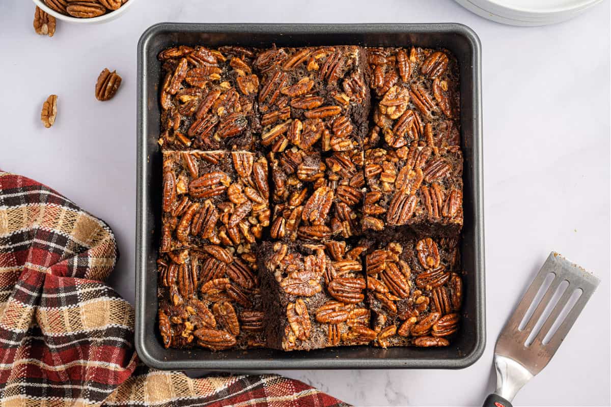 Pecan pie brownies baked in a square baking dish and cut into 9 large brownies.