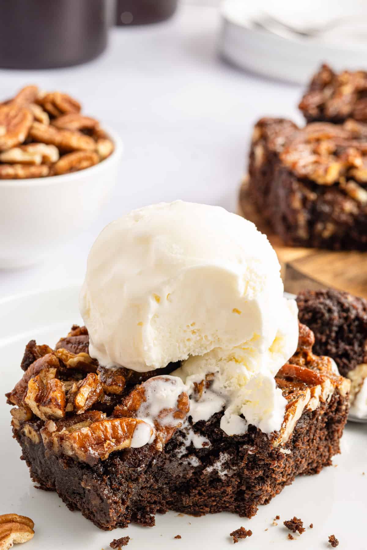 Pecan pie brownie topped with a scoop of vanilla ice cream.