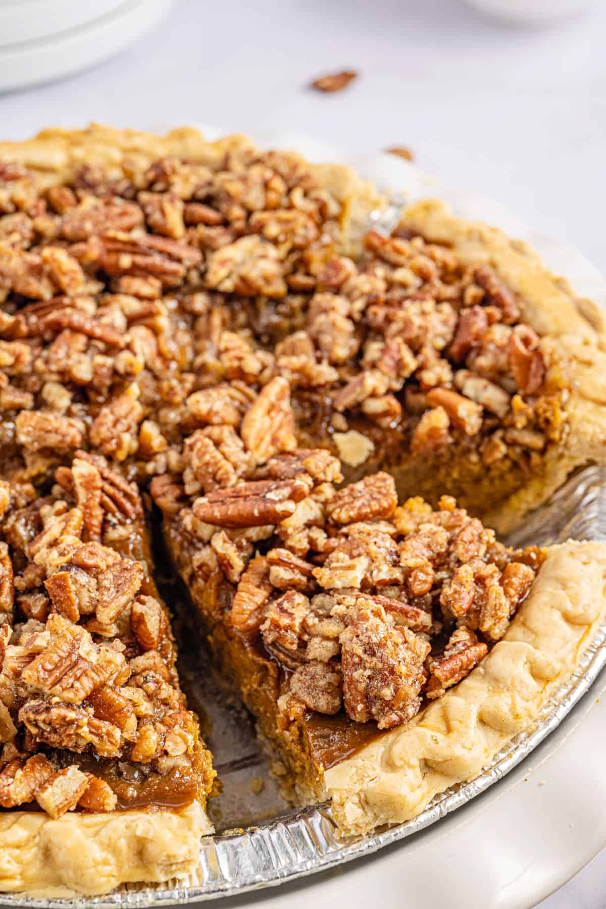 Pecan pumpkin pie cut into slices in a deep pie plate.