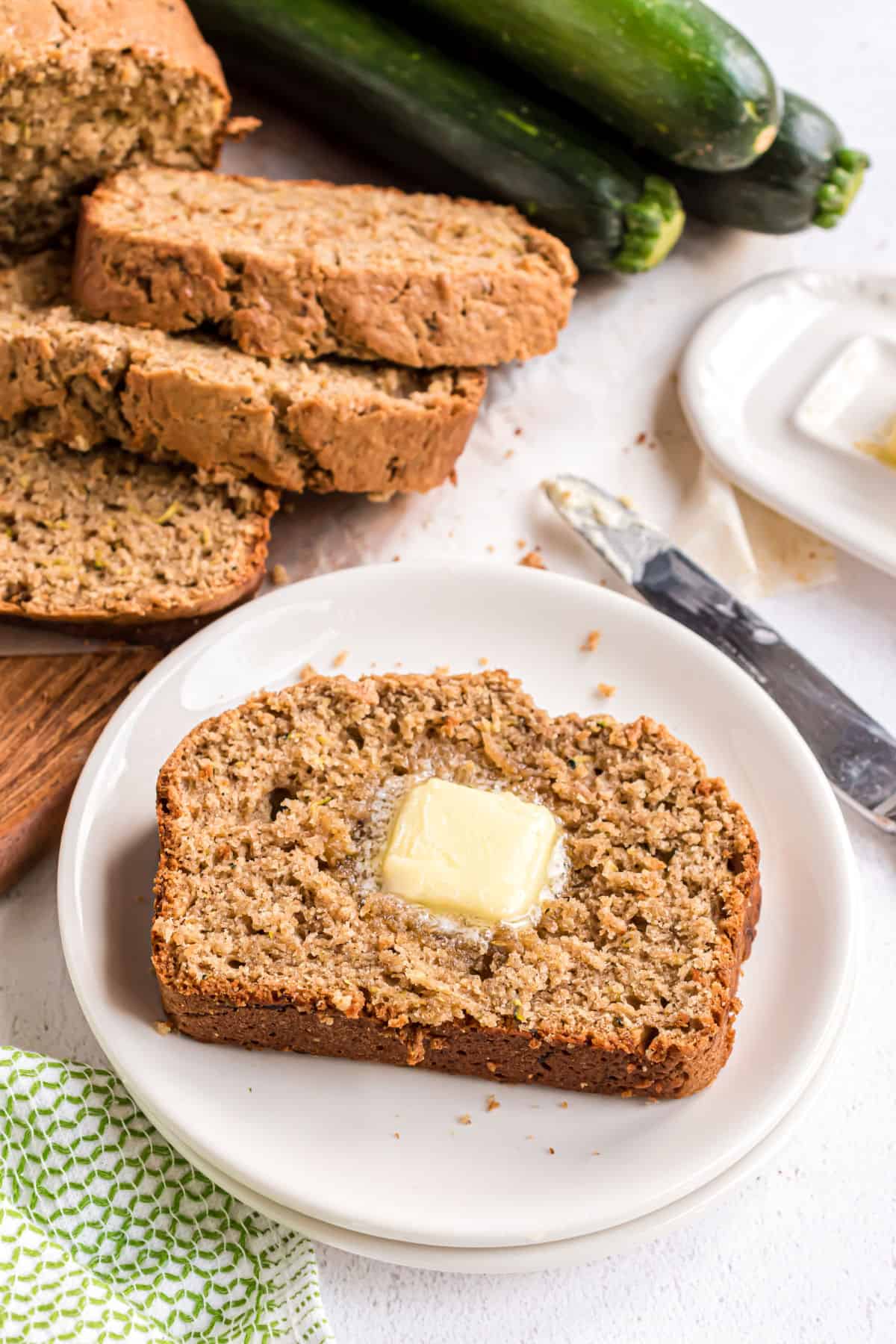 Slices of zucchini bread on white plates.