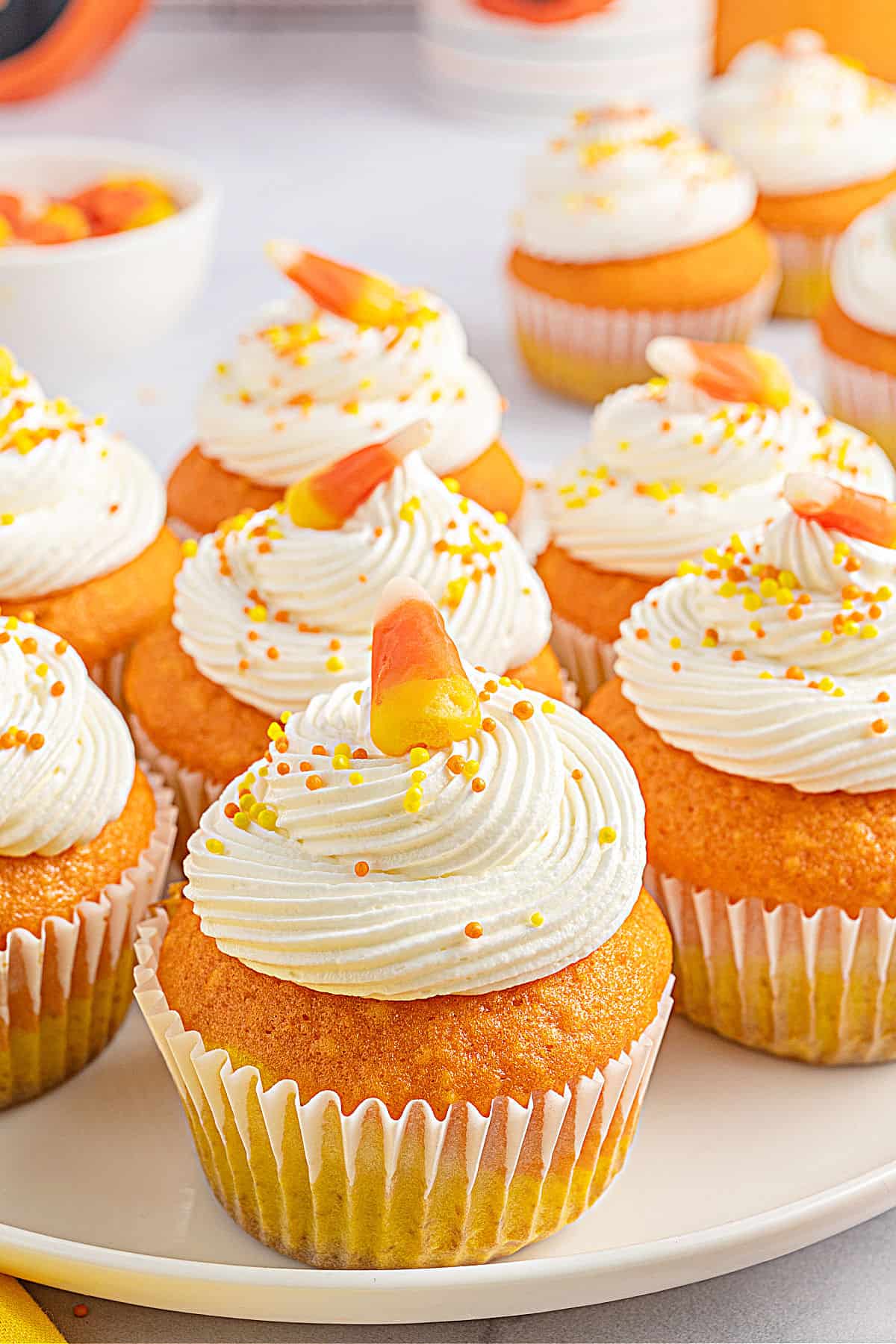 Candy corn cupcakes arranged on a white platter to serve.