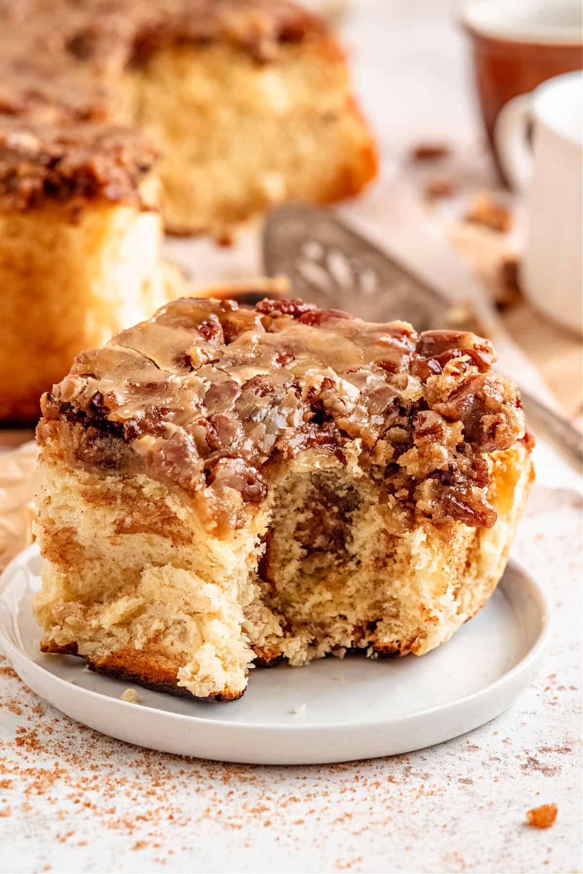 Pecan cinnamon roll with a bite taken out.