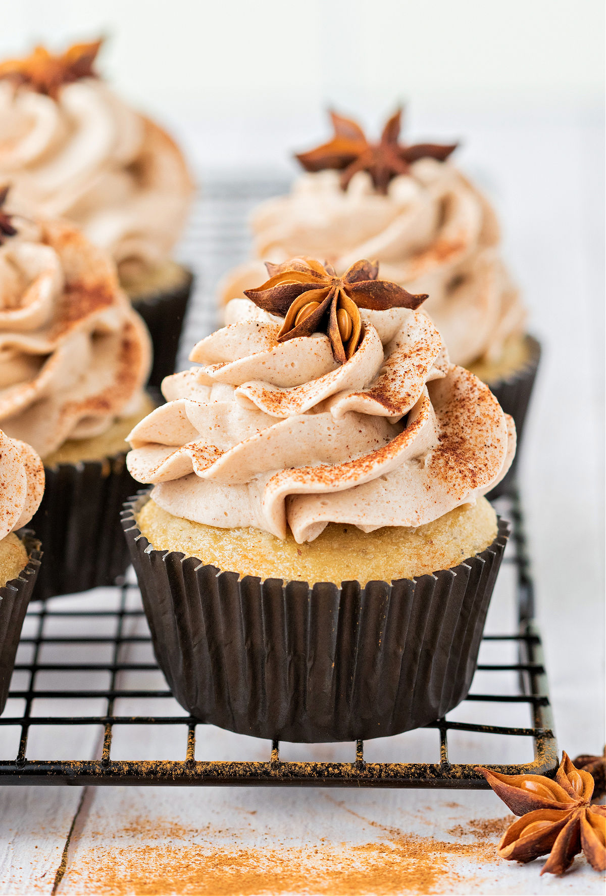 Chai cupcakes tooped with a swirl of chai frosting and a star anise.