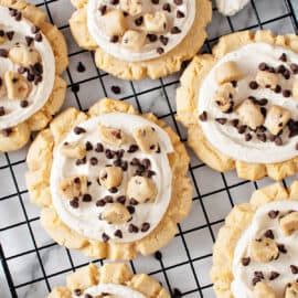 These Crumbl Cookie Dough Cookies have a buttery sugar cookie base that's topped with a rich vanilla buttercream frosting and crumbles of edible cookie dough and mini chocolate chips. These cookies are simple to make and truly epic in flavor!