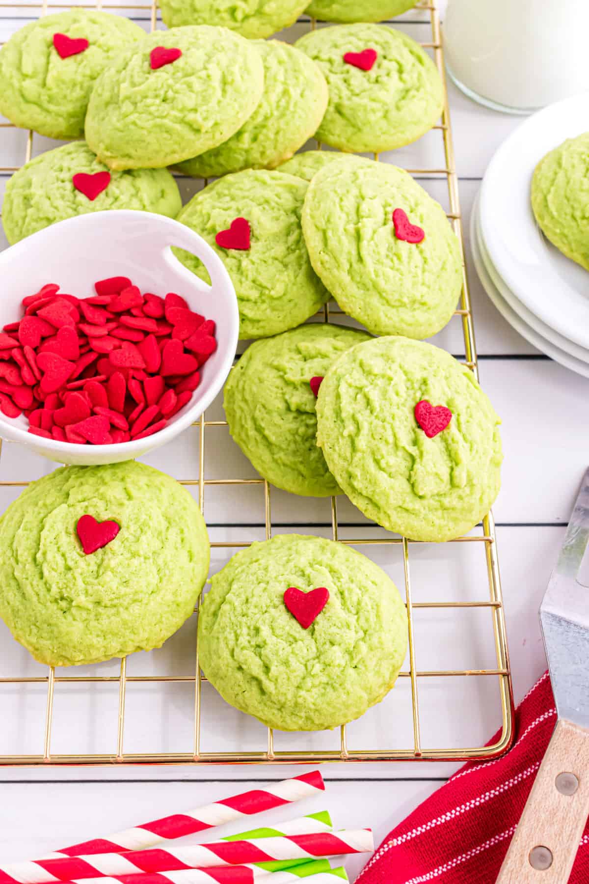 Grinch cookies stacked on a wire cooling rack.