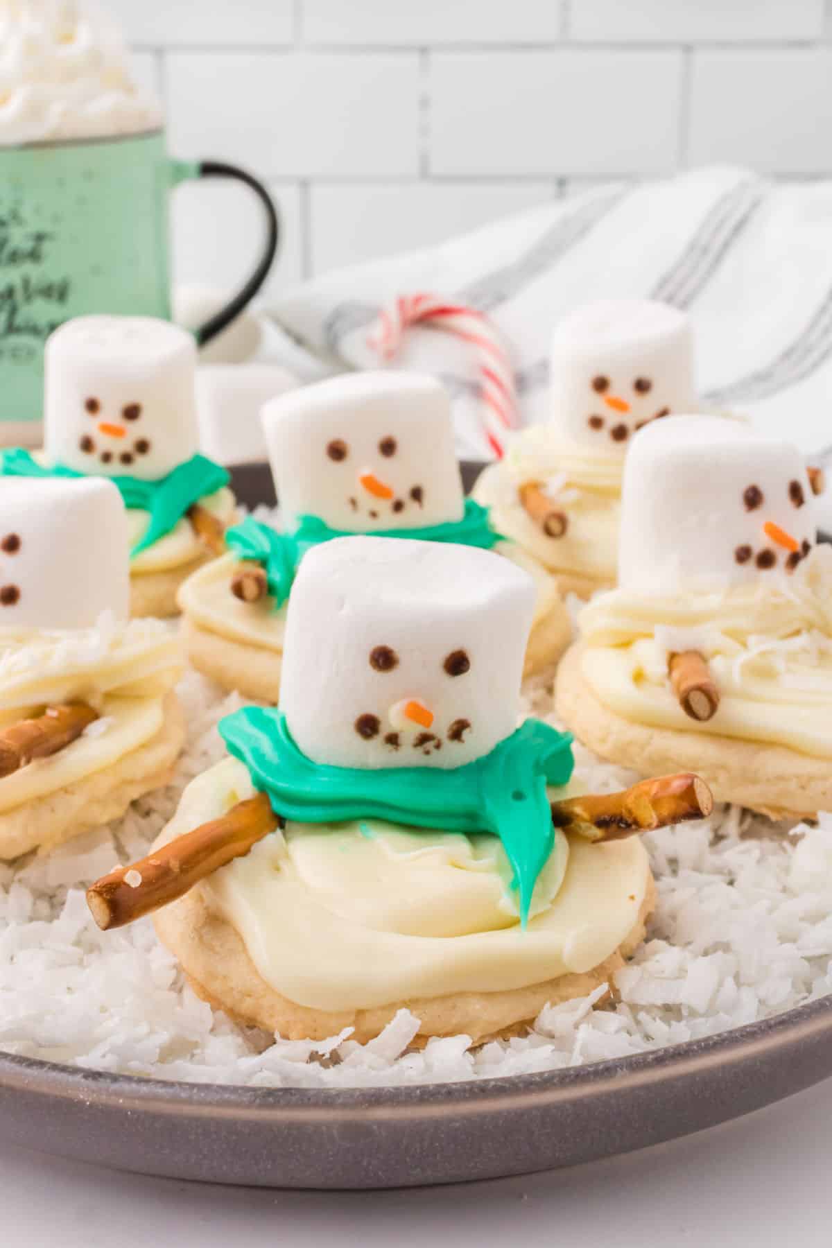 Sugar cookies topped with a marshmallow that looks like a melting snowman.