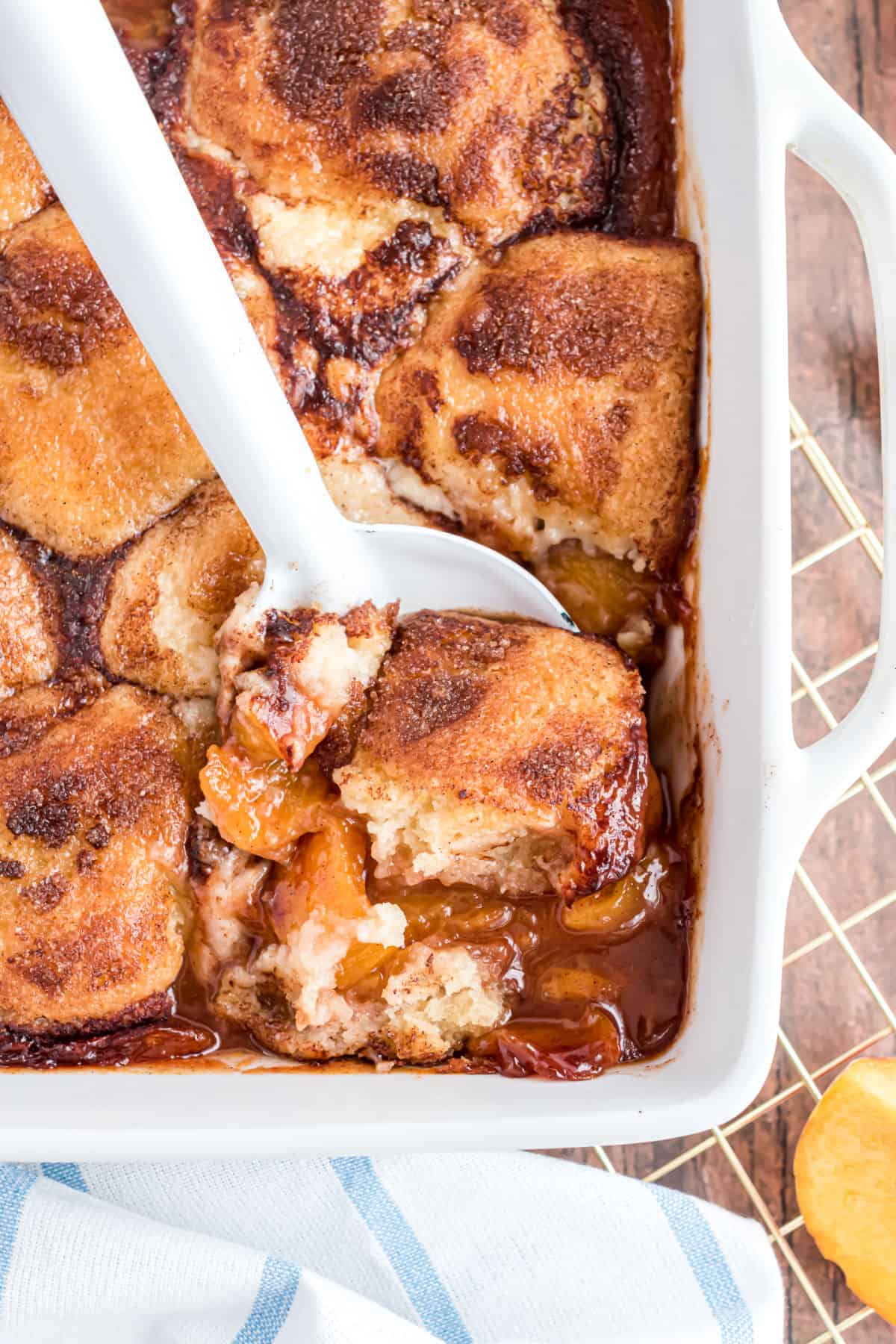 Peach cobbler in a white baking dish.