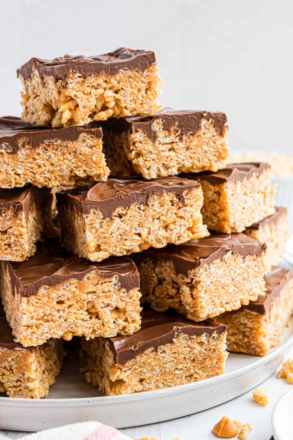 Scotcheroo bars stacked on a white serving plate.