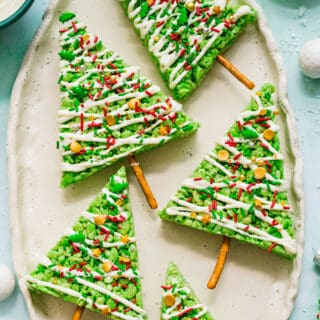 These cute and festive Christmas Tree Rice Krispie Treats are chewy and delicious, and topped with melted white chocolate and sprinkles for the tree's decorations! It's a perfect treat for the holidays!