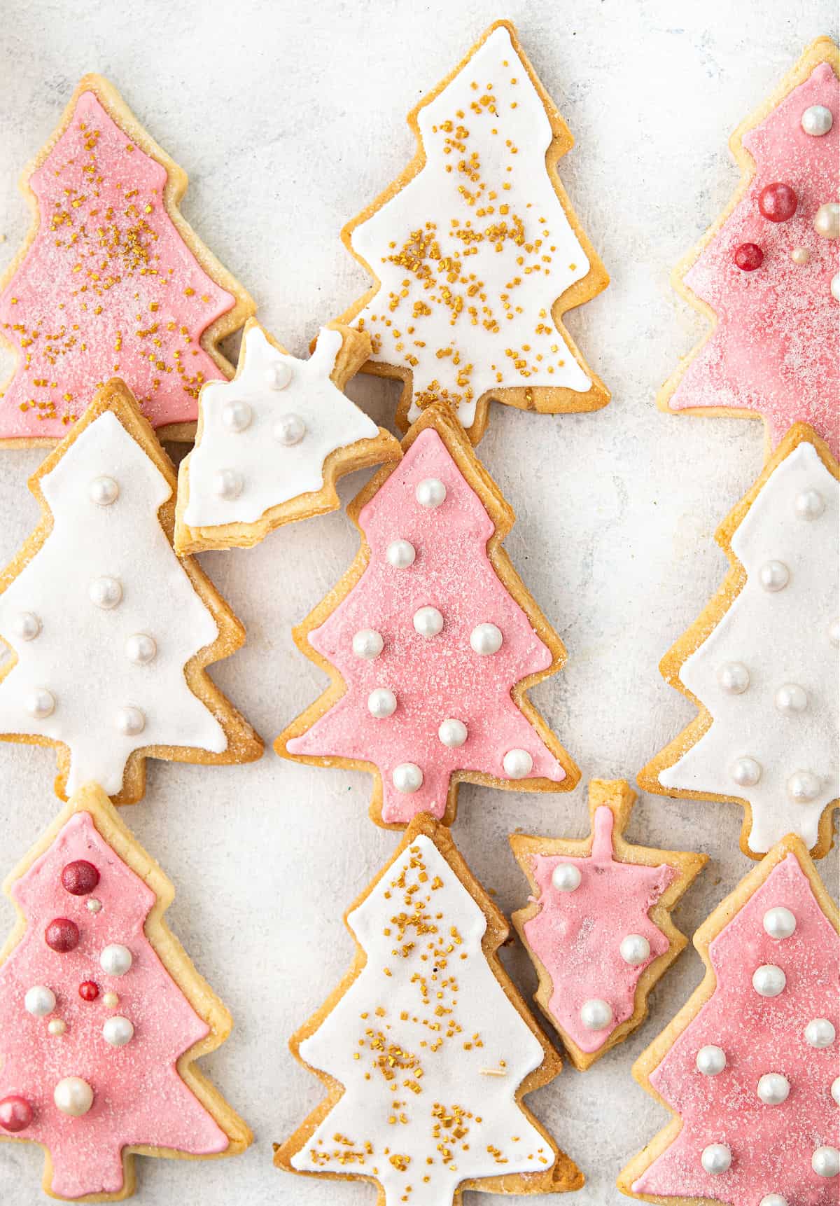 Pink and white iced cookies on parchment paper.