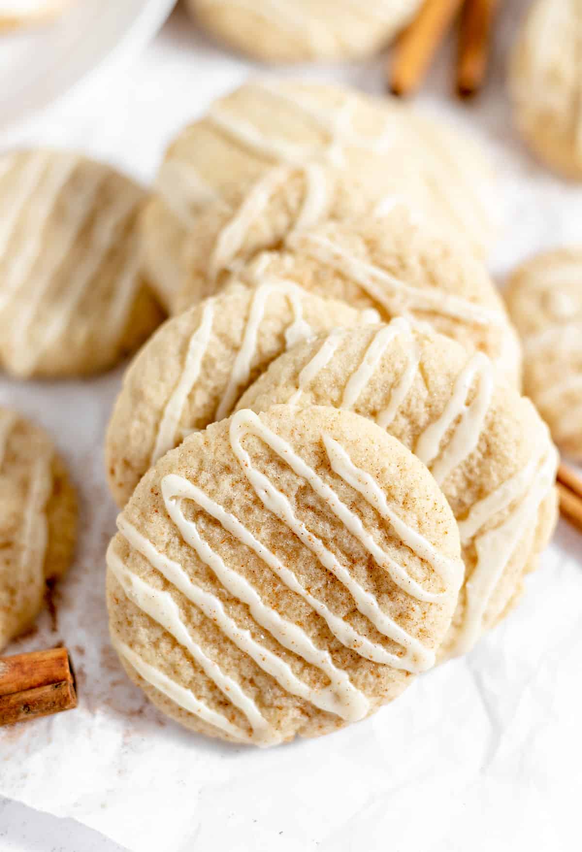 Eggnog cookies stacked on parchment paper.