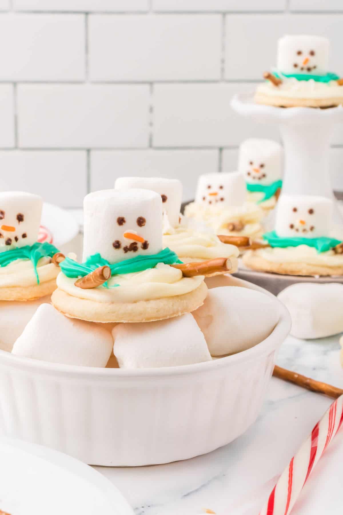 Melting snowman sugar cookies served on a bowl of marshmallows.