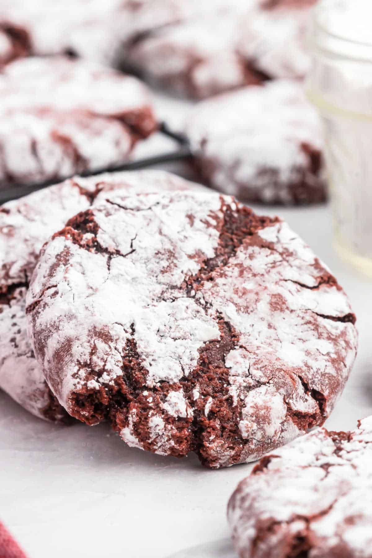 Red velvet cookies with powdered sugar on a baking sheet.