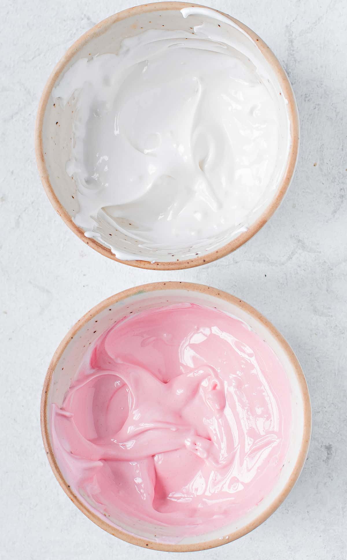 Royal icing tinted pink and white in separate bowls.