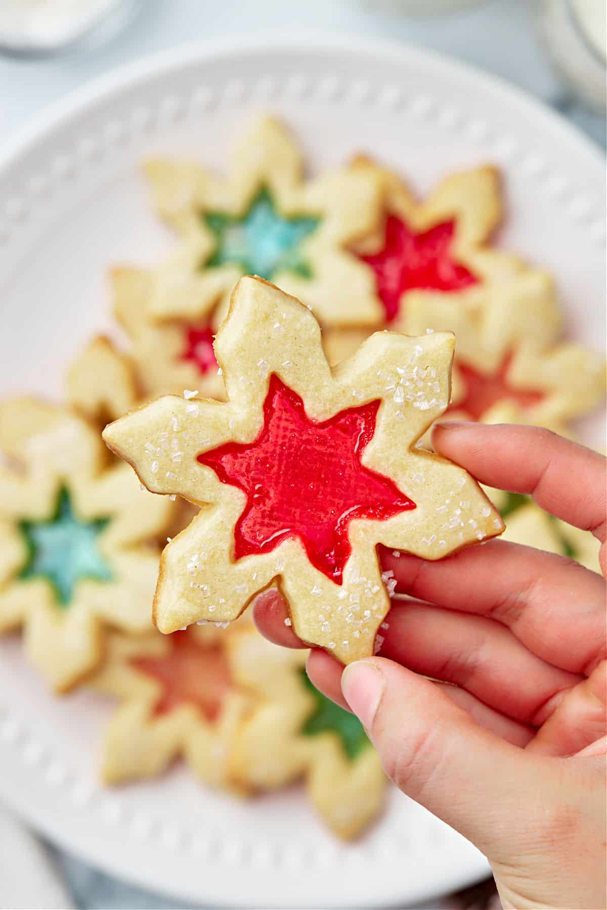 Star shaped stained glass cookies with red and green centers.