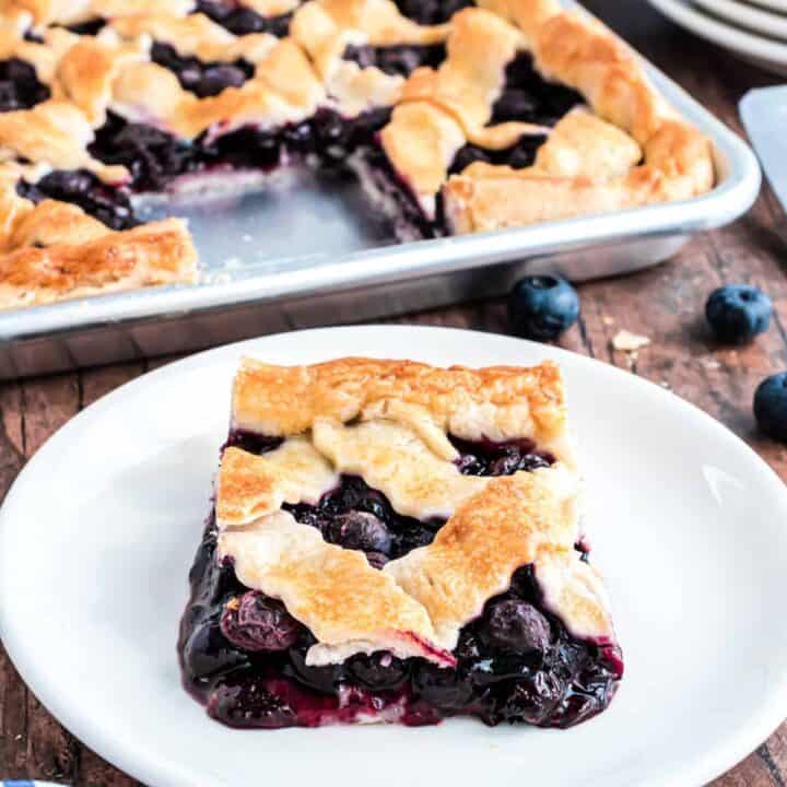 Blueberry Slab Pie is bursting with a sweet blueberry filling and covered in a flaky crust for a crowd-pleasing dessert that everyone will adore!
