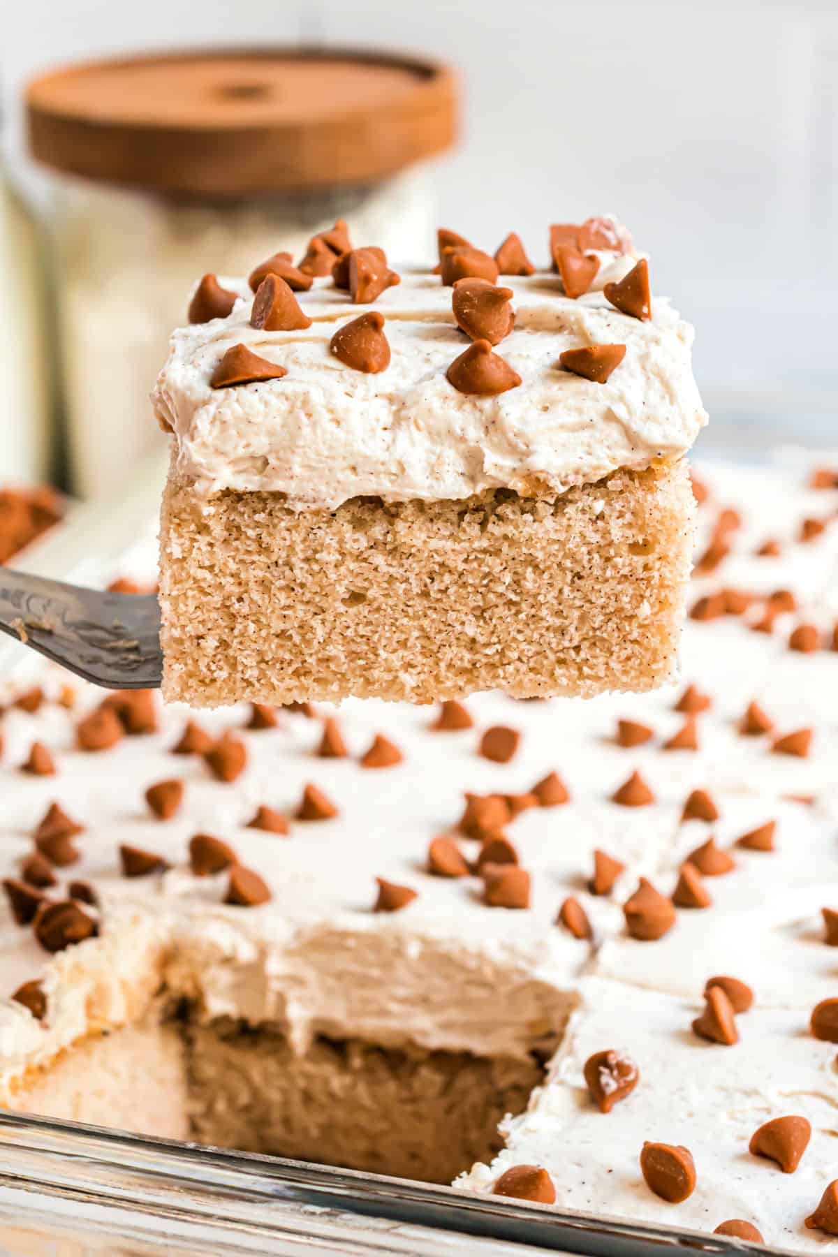 Cinnamon spice cake being lifted out of baking dish.