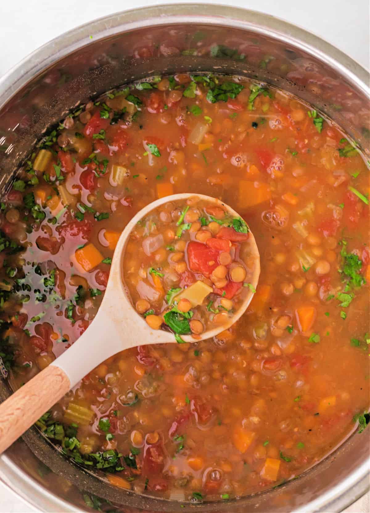 Lentil soup being ladled out of the Instant Pot.