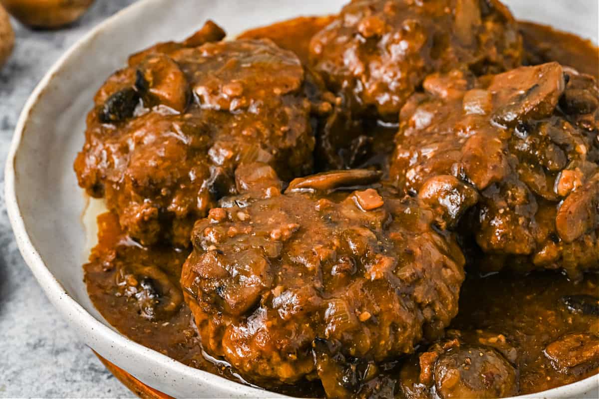 Salisbury steak in a white serving bowl.