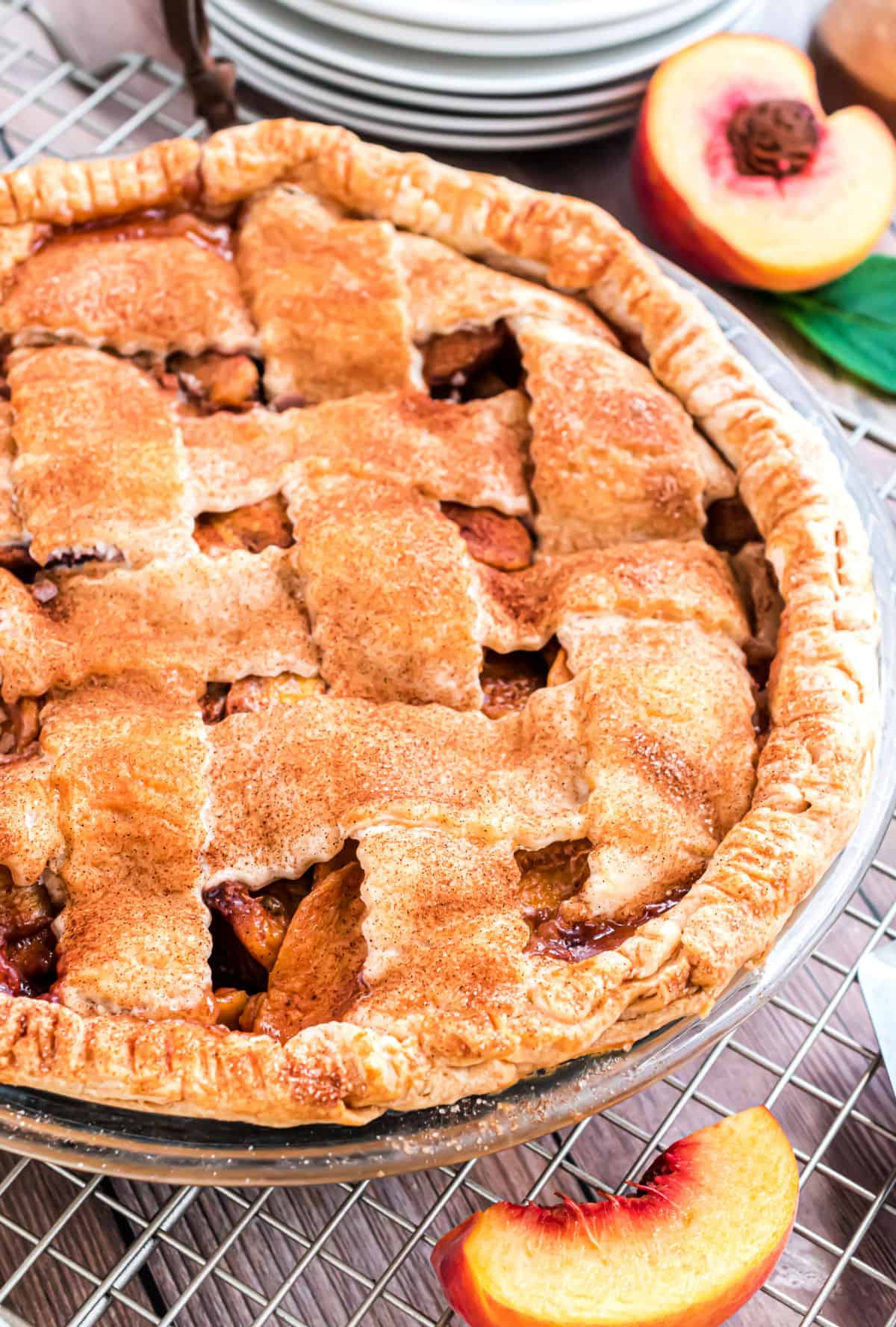 Fresh peach pie with lattice crust on a wire cooling rack.