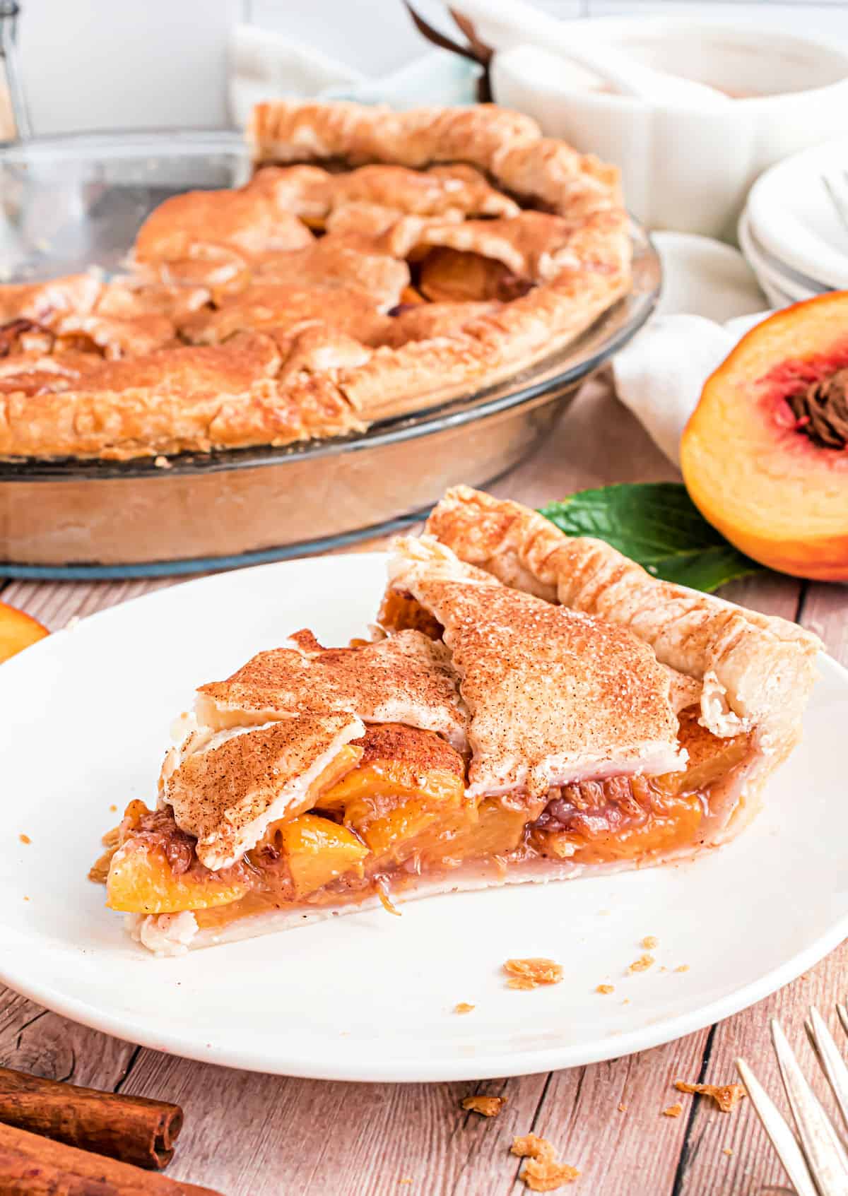 Slice of peach pie on a white plate.