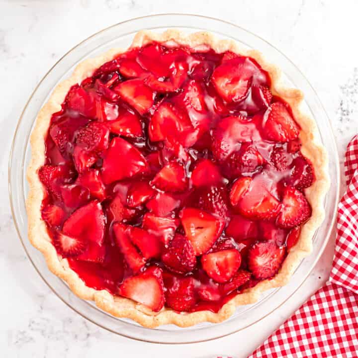A whole strawberry pie in a pie plate, uncut.