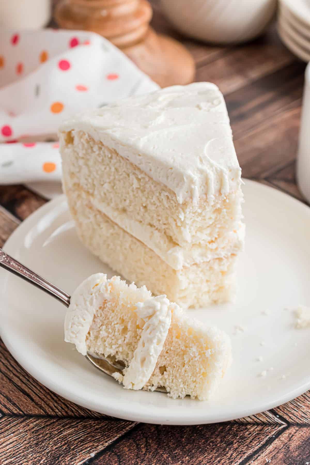 Slice of white cake with a bite taken out.